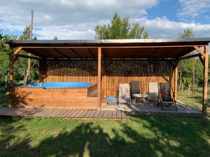 einen Pavillon mit einem Pool, 2 Stühlen und einem Tisch in der Unterkunft Rózsakő Ház in Badacsonytomaj