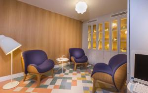 a waiting room with purple chairs and a laptop at Hotel le Lapin Blanc in Paris