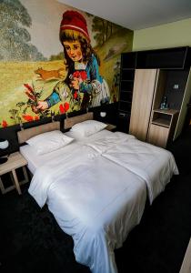 a bedroom with two beds with a painting on the wall at Hotel Viktorosa in Hofgeismar