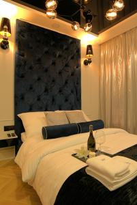 - une chambre avec un grand lit et une tête de lit noire dans l'établissement Blue Velvet Premium Apartments III, à Toruń