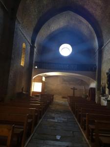 una iglesia vacía con techo azul y bancos de madera en Casa Rous, en Molló