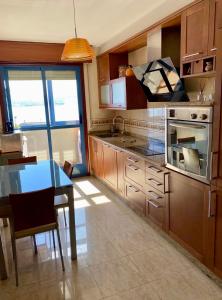eine Küche mit Tisch und Herd oberen Backofen in der Unterkunft PUNTA SALGUEIRÓN Vistas a la Ría - Navidad en Vigo sin Agobios- in Cangas