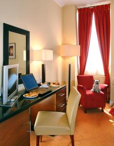 エディンバラにあるザ パーラメント ハウス ホテルのデスク、パソコン、赤い椅子が備わる客室です。