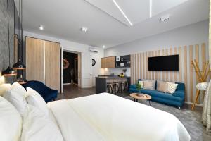 a bedroom with a white bed and a blue couch at Time Apartments Downtown, Zagreb city center in Zagreb