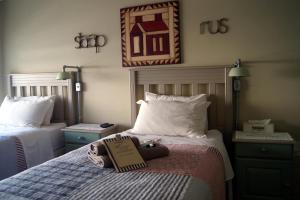 a hotel room with two beds and a sign on the bed at Homestead Guesthouse and Coffee Shoppe in Sasolburg +6 photos