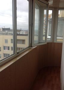 a room with three windows with a view of a city at Квартира-студия in Kharkiv