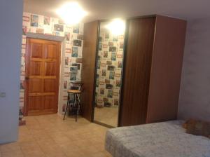 1 dormitorio con cama y pasillo con espejo en Квартира-студия en Járkov
