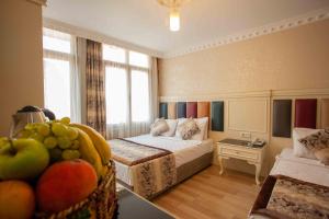 una habitación de hotel con una cama y una mesa con frutas en Best Nobel Hotel, en Estambul