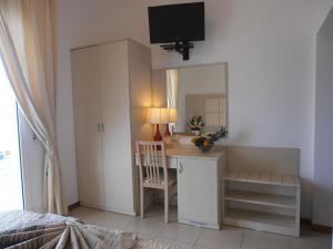 1 dormitorio con escritorio y espejo en Hotel Toscana, en Marotta