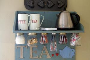 a shelf with coffee mugs and tea cups on it at Homestead Guesthouse and Coffee Shoppe in Sasolburg