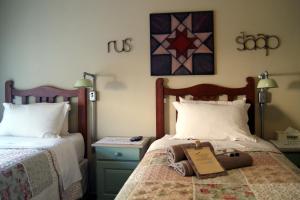 a bedroom with two beds and a sign on the bed at Homestead Guesthouse and Coffee Shoppe in Sasolburg