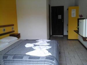 a hotel room with a bed with white towels on it at Pousada Thalud in Imbassai