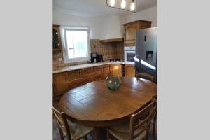 cocina con mesa de madera y nevera en Gîte en Cévennes, en Sumène