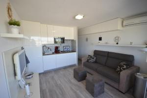 a living room with a couch and a kitchen at STUDIO VUE PORT ET MER in Valras-Plage