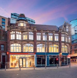 a large brick building with many windows on a street at easyHotel Birmingham in Birmingham