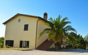 a house with a palm tree in front of it at Cardinal Girolamo in Montefalco