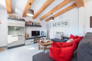 a living room with a couch and red pillows at Villa YESERO in Pollença