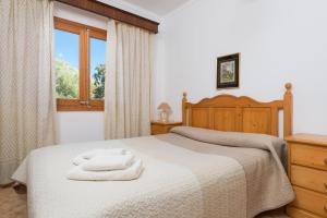 a bedroom with a bed with two towels on it at Villa YESERO in Pollença