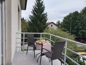a balcony with two chairs and a table with fruit on it at B&B Vila Teslova in Ljubljana