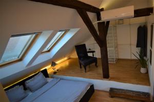 a bedroom with a bed and a chair and windows at CASA ADO in Oradea