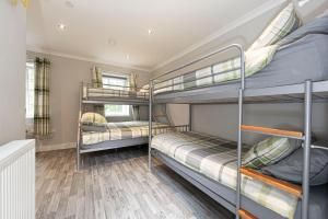 a bedroom with three bunk beds in a house at Ash Cottage in Merthyr Tydfil
