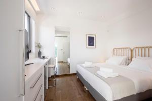 Un dormitorio blanco con una cama y un baño. en Eros Cyprus, en Ayia Napa 36 fotos más