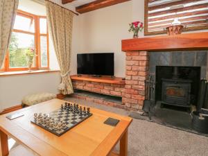 a living room with a chess board and a fireplace at Shipwreck Cottage in Millom