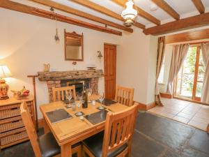 a dining room with a table and chairs and a fireplace at Shipwreck Cottage in Millom