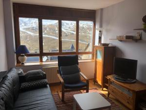 a living room with a couch and chairs and a window at Ski & relax Apartment in Formigal