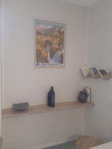 una mensola in una stanza con una foto sul muro di A la montagne à 2 App107 a Cauterets