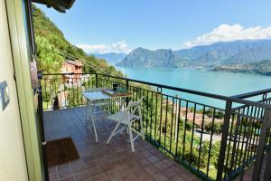 d'un balcon avec une table et une vue sur le lac. dans l'établissement Italian Vacation Homes - La Petite Maison du Lac, à Tavernola Bergamasca