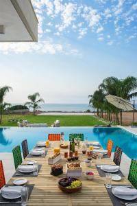 una mesa larga con comida junto a una piscina en Eros Cyprus, en Ayia Napa
