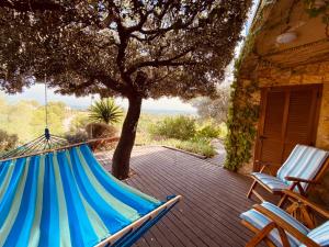 布尼約拉的住宿－Villa Liman，天井上的吊床,配有两把椅子和一棵树