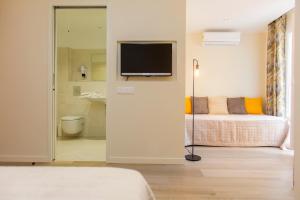 a bedroom with a bed and a television on a wall at Hotel Cesario in Calvi