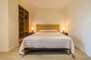 1 dormitorio con 1 cama con 2 lámparas en 2 mesas en Hotel Cesario en Calvi