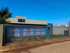 una valla frente a un edificio con cortinas blancas en Suítes em Capitolio, en Capitólio