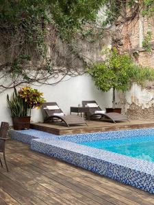 a swimming pool with lounge chairs next to at Hotel Boutique Hacienda Guadalupe in San Miguel de Allende