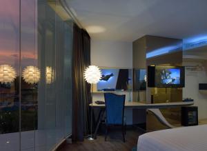 a bedroom with a desk and a television in a room at The Xtreme Suites in Bangkok
