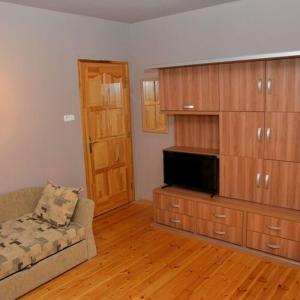 a living room with a couch and a entertainment center at Noszvaj Elite Apartman in Noszvaj