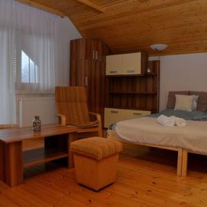 1 dormitorio con cama, escritorio y mesa en Noszvaj Elite Apartman en Noszvaj