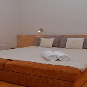 Una cama con dos toallas encima. en Noszvaj Elite Apartman, en Noszvaj