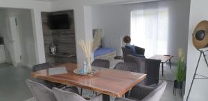 sala de estar con mesa de madera y sillas en Appartementhaus kleines Glück &MeineCardPLUS en Willingen
