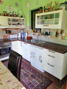 a kitchen with white cabinets and a sink at Szőlősi Diófa Vendégház in Balatonszőlős