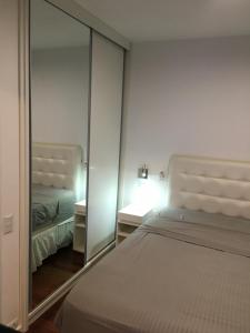 - une chambre avec un lit et un miroir dans l'établissement Newciti Flat Itaim Bibi, à São Paulo