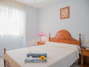 Un dormitorio con una cama con un girasol. en Apartamentos Irta Playa, en Alcossebre