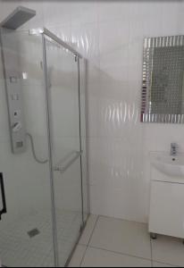 a white bathroom with a shower and a sink at Beverley Hills guesthouse in Queenstown +22 photos