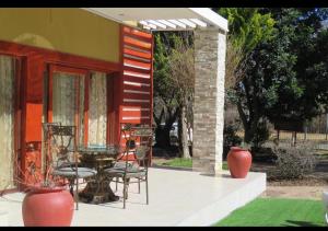 un patio con sillas y una mesa frente a una casa en Beverley Hills guesthouse, en Queenstown