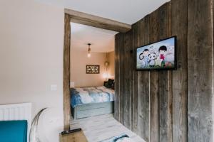 1 dormitorio con 1 cama y TV en la pared en Seagulls Nest Northern Ireland, en Newcastle