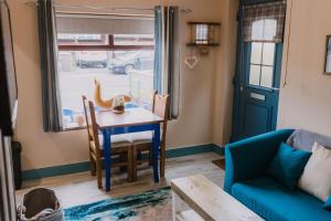 a living room with a table and a blue couch at Seagulls Nest Northern Ireland in Newcastle