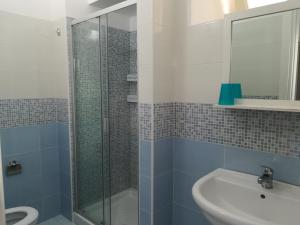bagno con doccia in vetro e lavandino di Casa vacanze Azure a Torre Suda